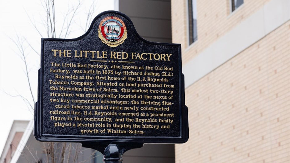 A photo of the historic marker dedication of "The Little Red Factory" for the R.J. Reynolds Tobacco Company's 150th Anniversary year.